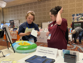 A young woman with Down syndrome sharing information with another young woman with Down syndrome